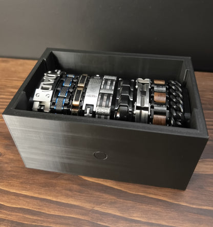 Black Cowan Cases watch, bracelet and necklace case filled with bracelets, face-up view from above
