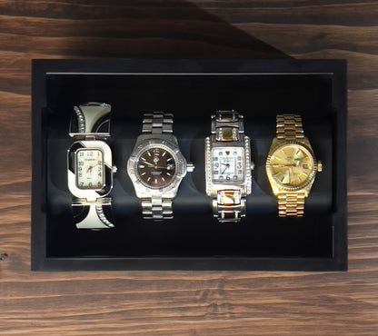 Black Cowan Cases watch, bracelet and necklace case holding four watches, face-up view from above