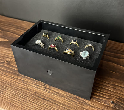 Black Cowan Cases earring, pendant, ring and cufflink case with pre-scored foam bed, filled with rings, angled view