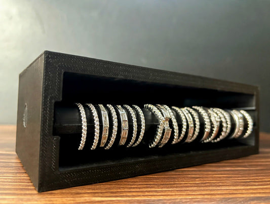 Black Cowan Cases ring case with slide-out ring bar filled with diamond band rings